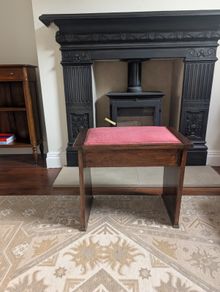 Antique piano stool with pink upholstered seat