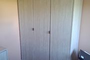 Three-door wardrobe in light wood effect finish