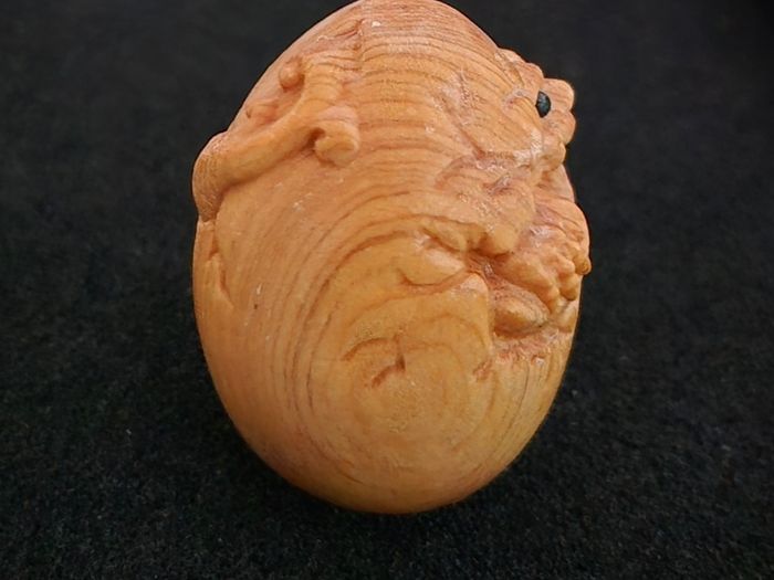 Carved wooden dragon hatching from an egg.