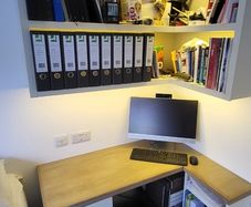 Office desk with wall hung shelving unit with LED lighting