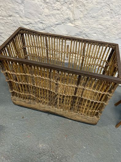 Large Victorian cane and metal laundry basket on wheels.