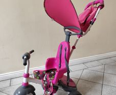 Pink toddler trike with parent handle and canopy