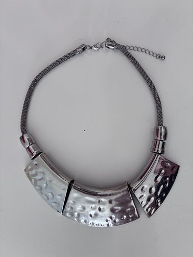 gunmetal-finished statement necklace features three curved, hammered metallic bars connected by a linked chain