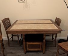 Wooden dining table with tiled top and matching chairs