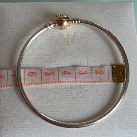 Pandora Moments two-tone bangle ir sterling silver with a 14k yellow gold ball clasp. (Size approx 19cm) for the right size please check all the photos (the bracelet is in very good condition)