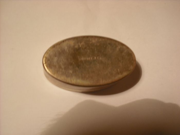 a antique pill box with golfer on it