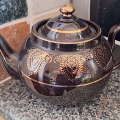 Antique dark brown glazed teapot featuring gold coloured arabesque and floral detailing. Resembles the classic 'Brown Betty'