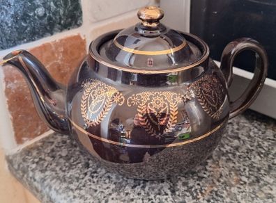 Antique dark brown glazed teapot featuring gold coloured arabesque and floral detailing. Resembles the classic 'Brown Betty'