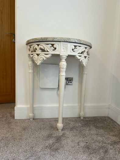 ornate half-moon console table with a granite top