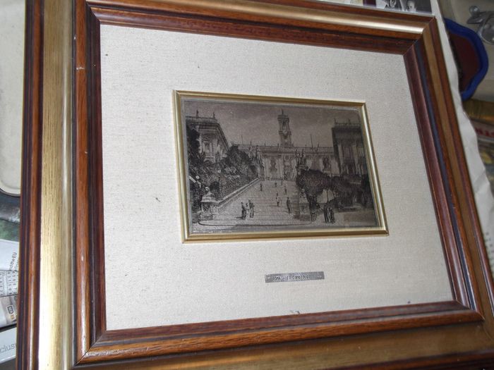 a picture with a silver plaque in the centre