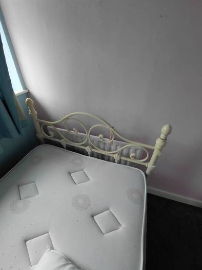 white metal single bed with mattress.