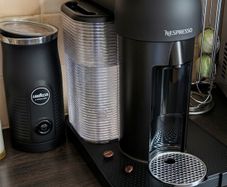 Nespresso coffee machine with lavazza frother and coffee pod stand