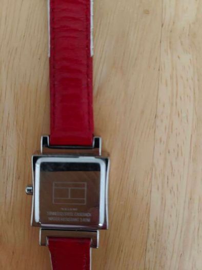 Tommy Hilfiger watch features a distinctive rectangular stainless steel case and a reversible red, white, and blue leather strap