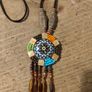 This is a bohemian-style long necklace featuring a resin pendant and beaded tassels. Image 2