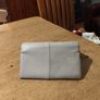 River Island clutch purse featuring a dual-texture gray flap panel design and a central dark metallic logo plate. Perfect inside. Image 4