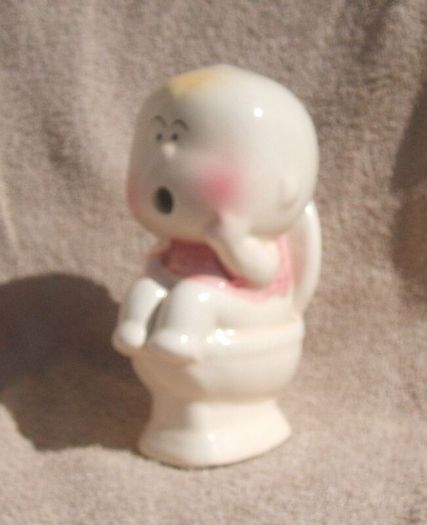 A vintage novelty money box in form of a young child sitting on a toilet (1930s to 1960s)