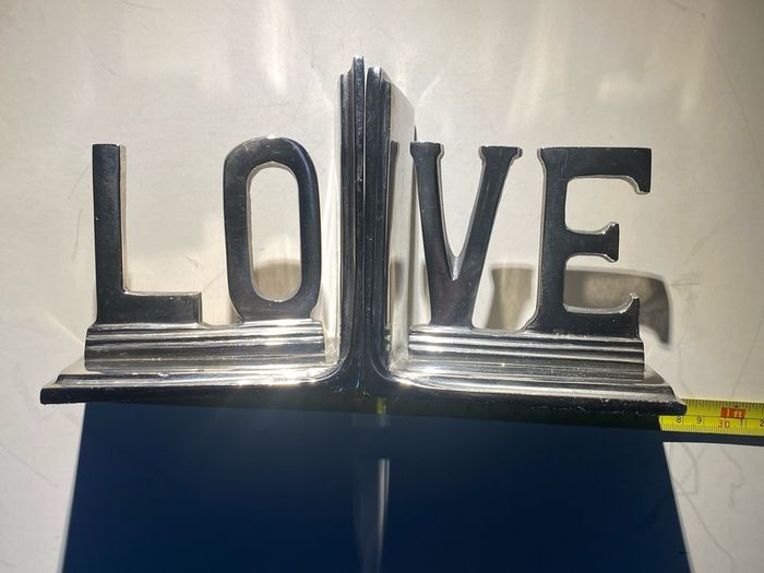bookends made of cast metal likely aluminum that spell love