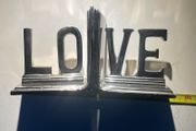 bookends made of cast metal likely aluminum that spell love