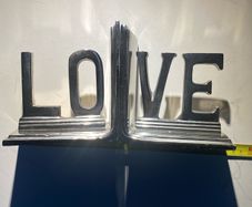 bookends made of cast metal likely aluminum that spell love