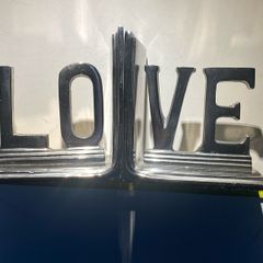 bookends made of cast metal likely aluminum that spell love