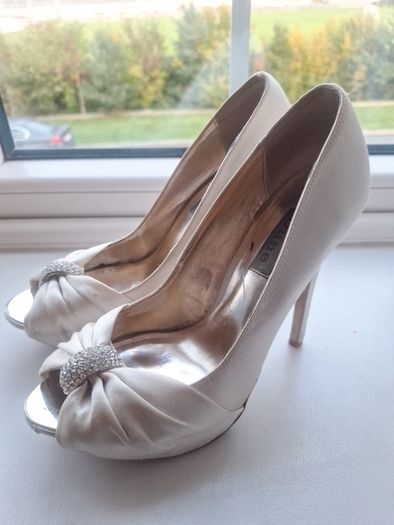Ivory satin peetoe high heel shoes by Dune London with a pleated bow trim accented with rhinestones