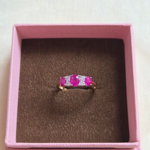 Beautiful yellow gold ring featuring three stunning rubies surrounded by sparkling cubic zirconia stones. Size M, in beautiful condition.