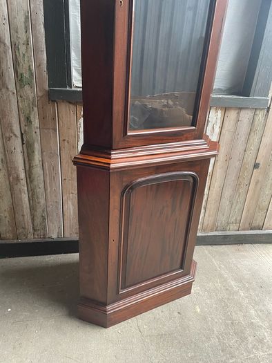 A tall mahogany corner cabinet.