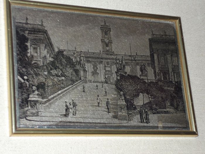 a picture with a silver plaque in the centre