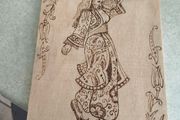 a piece of wood art featuring a pyrography (wood-burning) design of a woman in traditional attire.