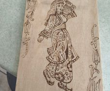 a piece of wood art featuring a pyrography (wood-burning) design of a woman in traditional attire.