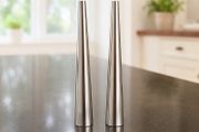 Two small stainless steel condiment shakers