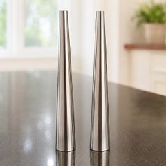 Two small stainless steel condiment shakers