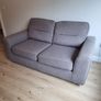 Grey two-seater sofa bed with matching storage footstool Image 3