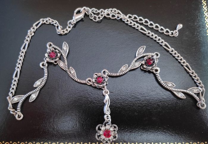 Silver tone floral necklace with red gemstone style accents