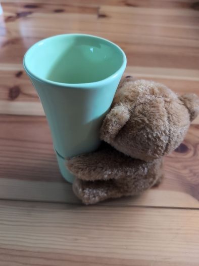 light green ceramic vase with teddy bear