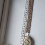 A large medallion featuring religious symbols, suspended from a long chain. Image 7
