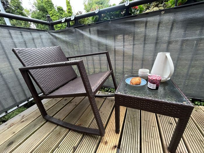Brown rattan outdoor table and rocking chair