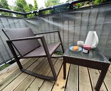 Brown rattan outdoor table and rocking chair