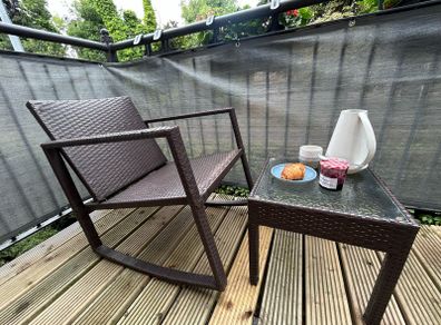 Brown rattan outdoor table and rocking chair