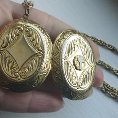 A large medallion featuring religious symbols, suspended from a long chain.