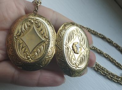A large medallion featuring religious symbols, suspended from a long chain.