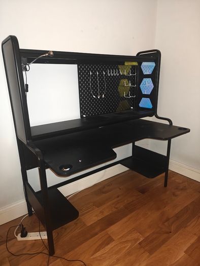 Black gaming desk with integrated pegboard and shelf