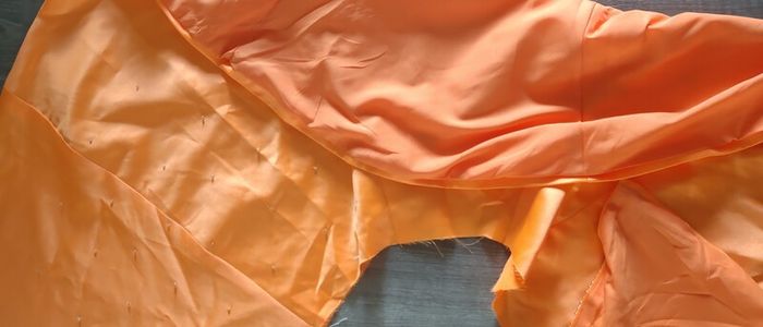 Solid orange satin look piece of fabric with beads