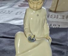 Porcelain Boy with Candle Nao by Lladro, depicting a seated child in a white nightshirt holding a small candle, postage available or collection