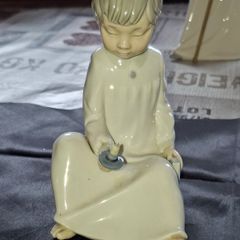 Porcelain Boy with Candle Nao by Lladro, depicting a seated child in a white nightshirt holding a small candle, postage available or collection