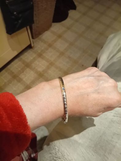 Silver tone bracelet with blue stones and words on it