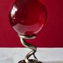 Red crystal/glass ball and metal serpent stand. Image 3