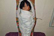 Vintage Native American baby on a sled porcelain doll