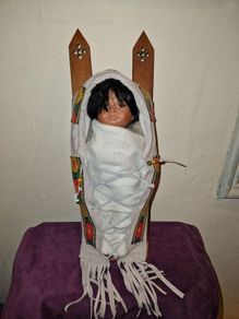 Vintage Native American baby on a sled porcelain doll
