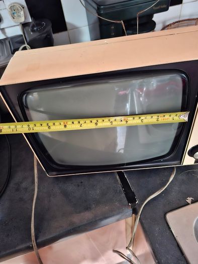 Ideal Prop, Vintage Working Boots Audio TV12 Portable Black and White CRT Television, featuring a cream plastic casing with side control dials and a 12 inch screen. Designed with dual power capabilities supporting standard mains voltage (240V) as well as 
